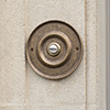 Door Bell Cover in Antiqued Brass with Ceramic Bell Push
